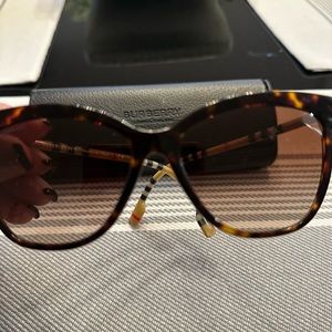 Burberry sunglasses. Classic Burberry design on arms of glasses.
